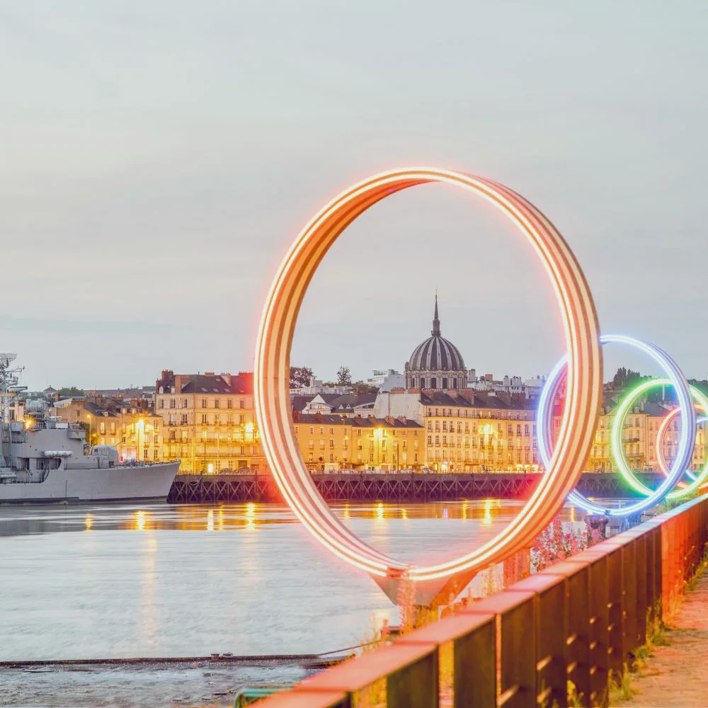 Nantes, les Anneaux lumineux du quai des Antilles au bord de la Loire, avec le dôme de Notre-Dame-de-Bon-Port en arrière-plan