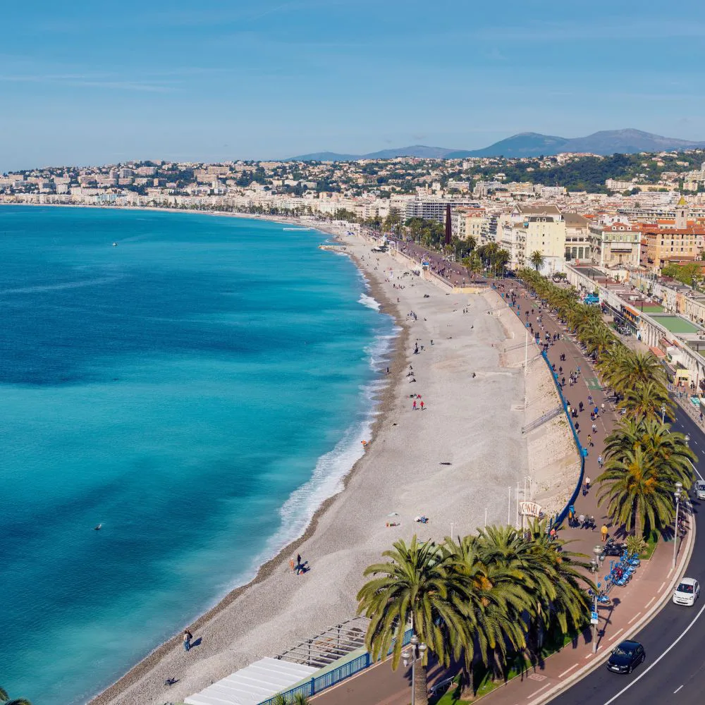 Nice, la promenade des Anglais, ses palmiers et la plage de galets le long de la baie des Anges