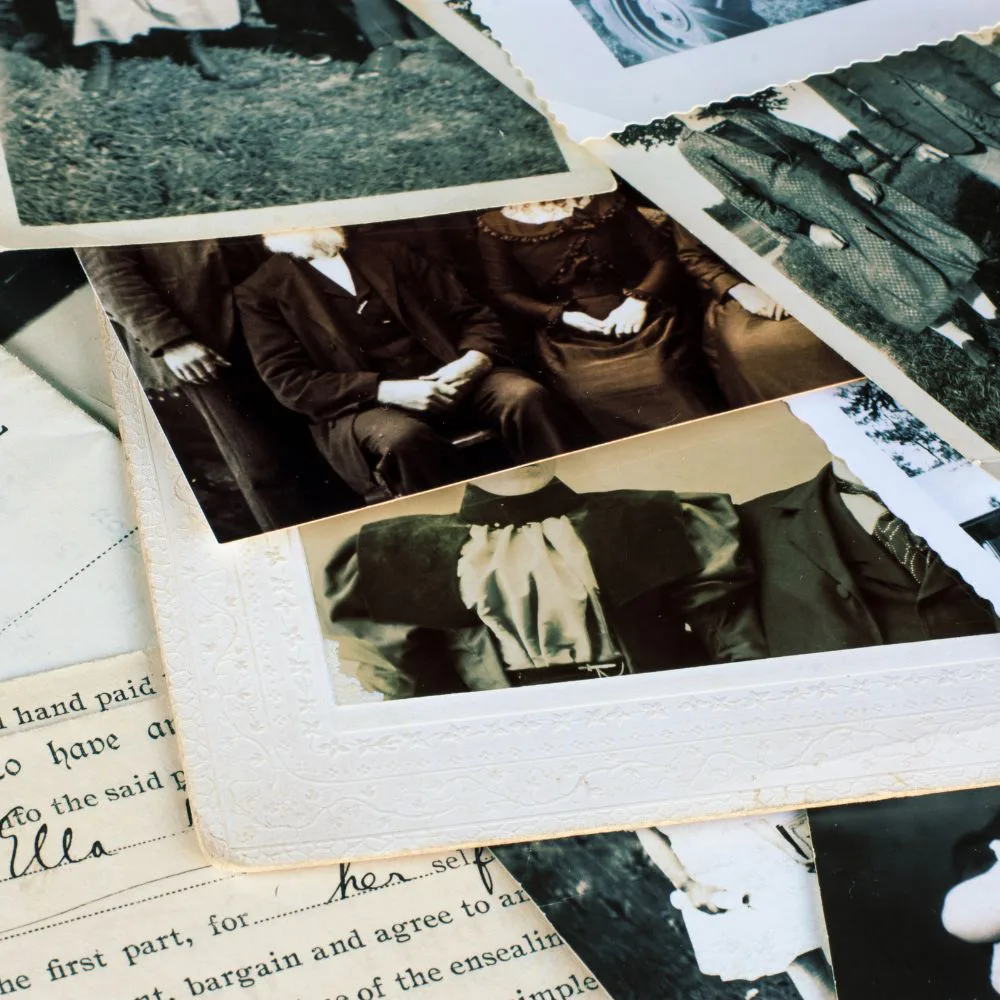 Photos de famille anciennes en noir et blanc, étalées sur un vieux document manuscrit